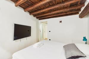 ein Schlafzimmer mit einem Bett und einem Fernseher an der Wand in der Unterkunft iFlat Marvellous home near Via del Corso in Rom