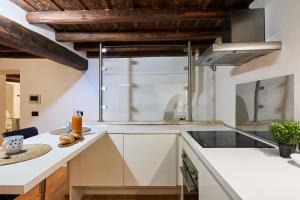 eine Küche mit weißer Arbeitsplatte und Holzdecken in der Unterkunft iFlat Marvellous home near Via del Corso in Rom