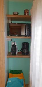 una pequeña cocina con microondas en un estante en Marina Apartment, en Bari Sardo