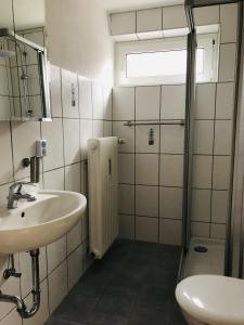 a white bathroom with a sink and a shower at Ferienwohnung Am Kurpark 
