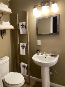 a bathroom with a sink and a toilet and a mirror at Louisiana State Cabin in West Point
