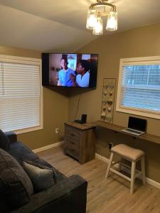 een woonkamer met een flatscreen-tv aan de muur bij Louisiana State Cabin in West Point