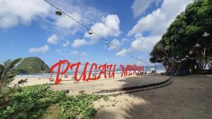 uma praia com um monte de bandeiras vermelhas em Omah Joglo Pulau Merah em Pasanggaran