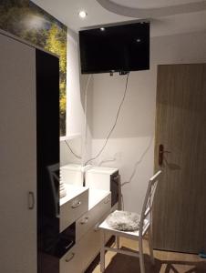 Apartamenty na doby في سيدلس: غرفة بها مكتب مع كرسي وتلفزيون على الحائط