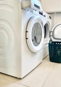 two white washing machines in a laundry room at Ferienhaus Piratennest Rügen in Dranske