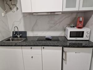 a kitchen counter with a microwave and a sink at Alfama - Close to Everything in Lisbon