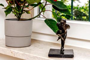 a bronze statue of a boy on a shelf next to a plant at Augusto - your family house in the heart of Lisbon in Lisbon