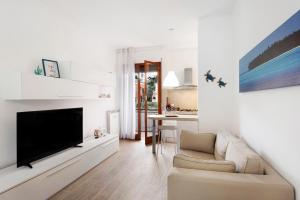 uma sala de estar com uma televisão grande e um sofá em Casa Sara em Arenzano
