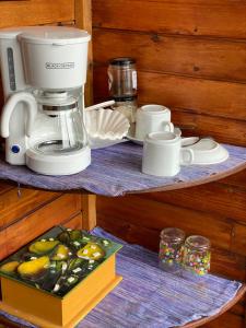 a coffee maker on a shelf with a box of fruit at Lakefront Chalet in San Juan La Laguna