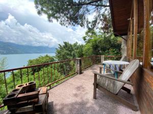 a porch with a bench and a view of the water at Lakefront Chalet in San Juan La Laguna