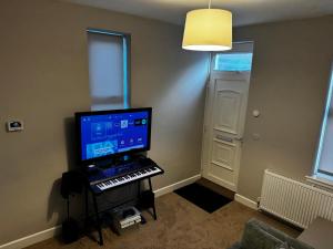 a room with a keyboard and a computer on a stand at Orionn Place in Nottingham