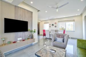 un soggiorno con TV a schermo piatto a parete di Premium 2BHK Apartment with pool at Candolim Beach a Candolim