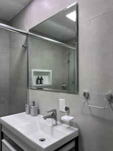 baño con lavabo y espejo grande en (109)Flat Poeta Drummond Jardins (Apt Particular), en São Paulo