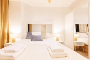 een slaapkamer met een groot wit bed en 2 spiegels bij Bravissimo Auriga, Old town retreat in Girona
