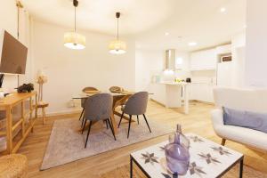 a kitchen and living room with a table and chairs at Bravissimo Auriga, Old town retreat in Girona