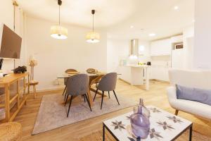 een keuken en een woonkamer met een tafel en stoelen bij Bravissimo Auriga, Old town retreat in Girona