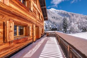 a wooden building with a balcony with snow on it at Spacious family chalet with balcony and garden in Chamonix