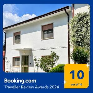 een wit huis met een geel bord waarop staat reisbeoordeling bij La Villetta nel Delta in Mesola
