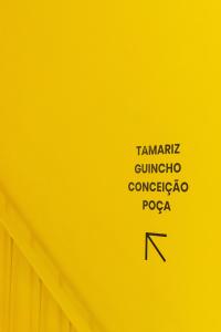 a yellow wall with some writings on it at Surf & Sea Suites in Parede