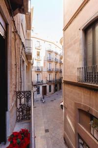 een balkon met uitzicht op een straat met bloemen bij Bravissimo Auriga, Old town retreat in Girona