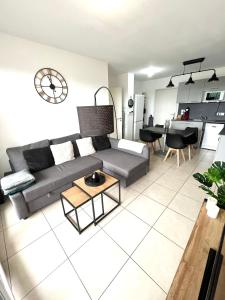 ein Wohnzimmer mit einem Sofa und einem Tisch in der Unterkunft Superbe appart avec Jardin à 2 min de l’Aéroport-4 pers in Vitrolles
