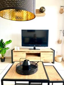 a living room with a tv and a coffee table at Superbe appart avec Jardin à 2 min de l’Aéroport-4 pers in Vitrolles