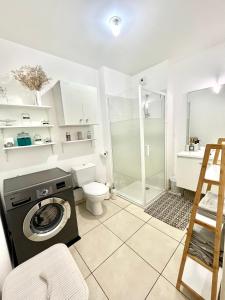 uma casa de banho com uma máquina de lavar roupa e um chuveiro em Superbe appart avec Jardin à 2 min de l’Aéroport-4 pers em Vitrolles