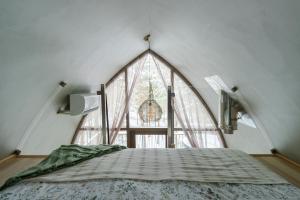 a bed in a room with a large window at Jungle SPA bungalows in Žocenes Ciems +95 photos