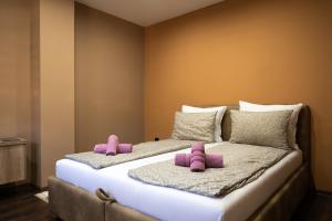 a bedroom with two beds with pink slippers at Ema, Asja, Eda Apartments in Zenica