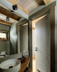 a bathroom with a white sink and a mirror at Jungle SPA bungalows in Žocenes Ciems