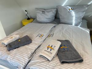 a bed with towels and pillows on it at Bootshaus SunDeck - Strandnah in den Dünen in Wangerooge