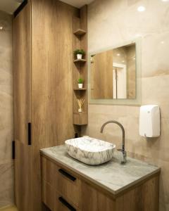 a bathroom with a sink and a mirror at Ema, Asja, Eda Apartments in Zenica