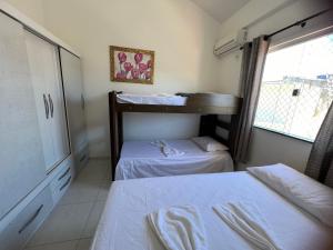 two bunk beds in a room with a window at Coroa Aconchego in Porto Seguro