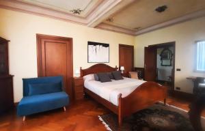 una camera da letto con un letto e una sedia blu di Ecco Marino Casa Vacanze a Marino