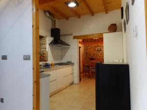 a kitchen with a black refrigerator in a room at El Bierzo Oro en el Camino in Villaverde de la Abadía