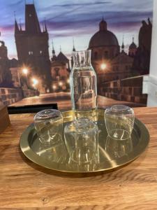 a glass tray with four empty glasses on a table at Hotel Oáza Praha in Prague