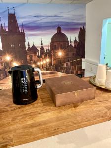 uma caneca de café e uma caixa numa mesa de madeira em Hotel Oáza Praha em Praga