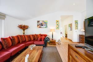 a living room with a red couch and a tv at Meer & Wald Wellness Appartements in Heringsdorf