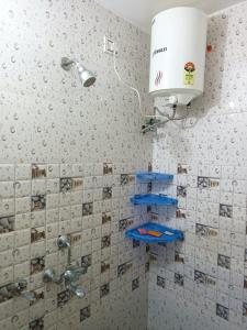 La salle de bains est pourvue d'une douche et d'étagères bleues. dans l'établissement Om Home Stay, à Ayodhya