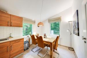 a kitchen with a wooden table and chairs at Meer & Wald Wellness Appartements in Heringsdorf