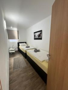 2 łóżka w małym pokoju z drzwiami w obiekcie Apartment Marija w mieście Tisno