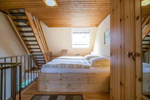 a bed in the middle of a room with a staircase at Ferienhaus an der Baeke D in Bad Zwischenahn