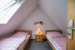 two beds in a attic with a lamp on a night stand at Ferienhaus an der Baeke D in Bad Zwischenahn