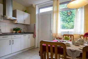 a kitchen and dining room with a table and a window at Ferienhaus an der Baeke D in Bad Zwischenahn
