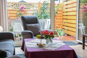 a table with a purple table cloth and flowers on it at Ferienhaus an der Baeke B in Bad Zwischenahn