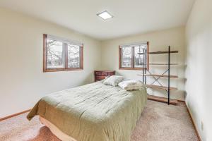 a bedroom with a bed and two windows at Convenient Racine Home 4 Mi to Lake Michigan! in Racine