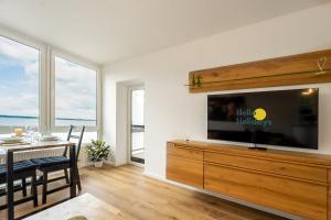 ein Wohnzimmer mit einem TV und einem Esstisch in der Unterkunft Yachthafen am Delf in Bad Zwischenahn