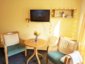 a room with two chairs and a table and a tv at L8 - Urlaubsmagie- Helle Unterkunft am Wanderweg in Sebnitz