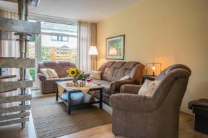 a living room with two couches and a table at Ferienhaus an der Baeke A in Bad Zwischenahn