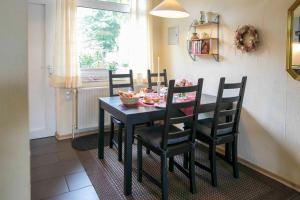 a black dining room table and chairs in a room at Ferienhaus an der Baeke A in Bad Zwischenahn